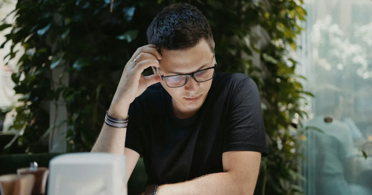 転職エージェントと転職サイトの違いについて、デスクで悩む40代男性