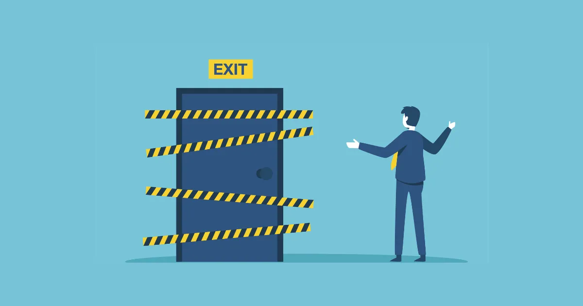 出口がふさがれているドアの前で立ち尽くすスーツの男性。会社が辞めさせてくれない絶望的な状況を表している