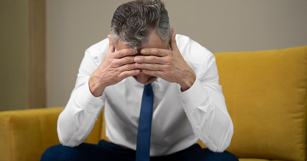 転職後に自信を失い、頭を抱えている中年の男性。転職者の孤独な戦いを表している