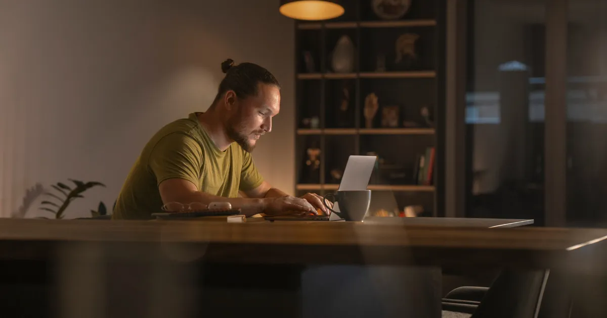 夜遅く一人でパソコンに向き合う男性。副業でwebライターをしている