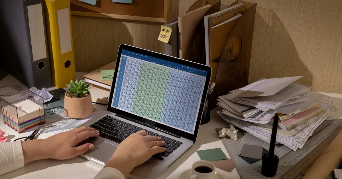 パソコンとその横に置かれたたくさんの領収書の山。このセクションのテーマ「確定申告」へ向けての経費の記録方法についての記事の始まりを示している