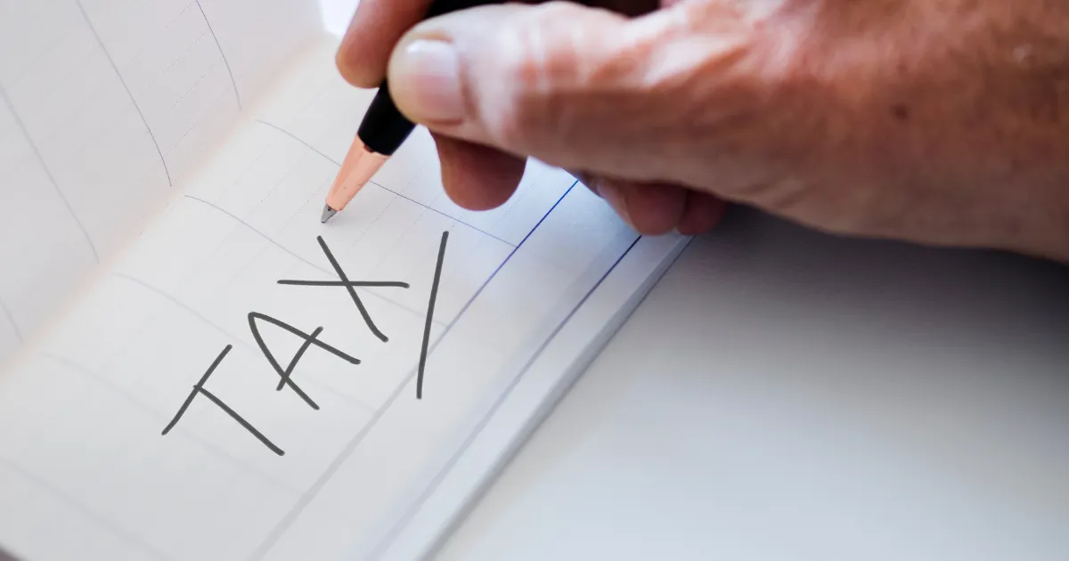 鉛筆で「TAX」の文字を書くヒトの画像。このセクションのテーマ「節税」について表している