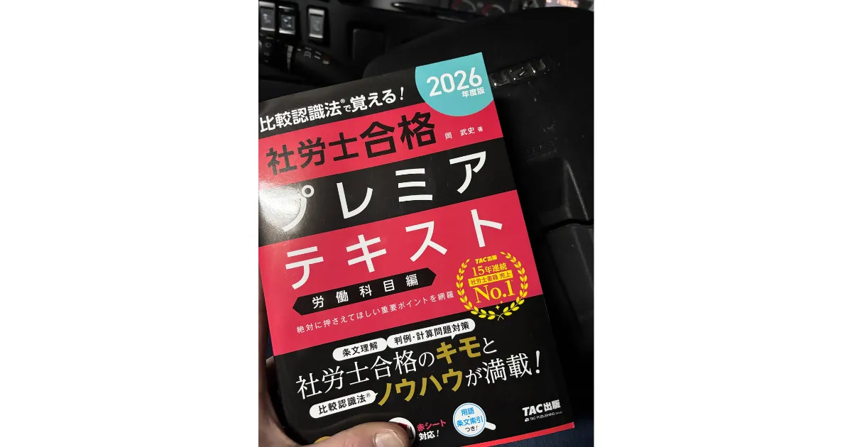 40代トラック運転手の「僕」が再起のために勉強している『2026年度版 社労士合格プレミアテキスト 労働科目編』の実物写真。