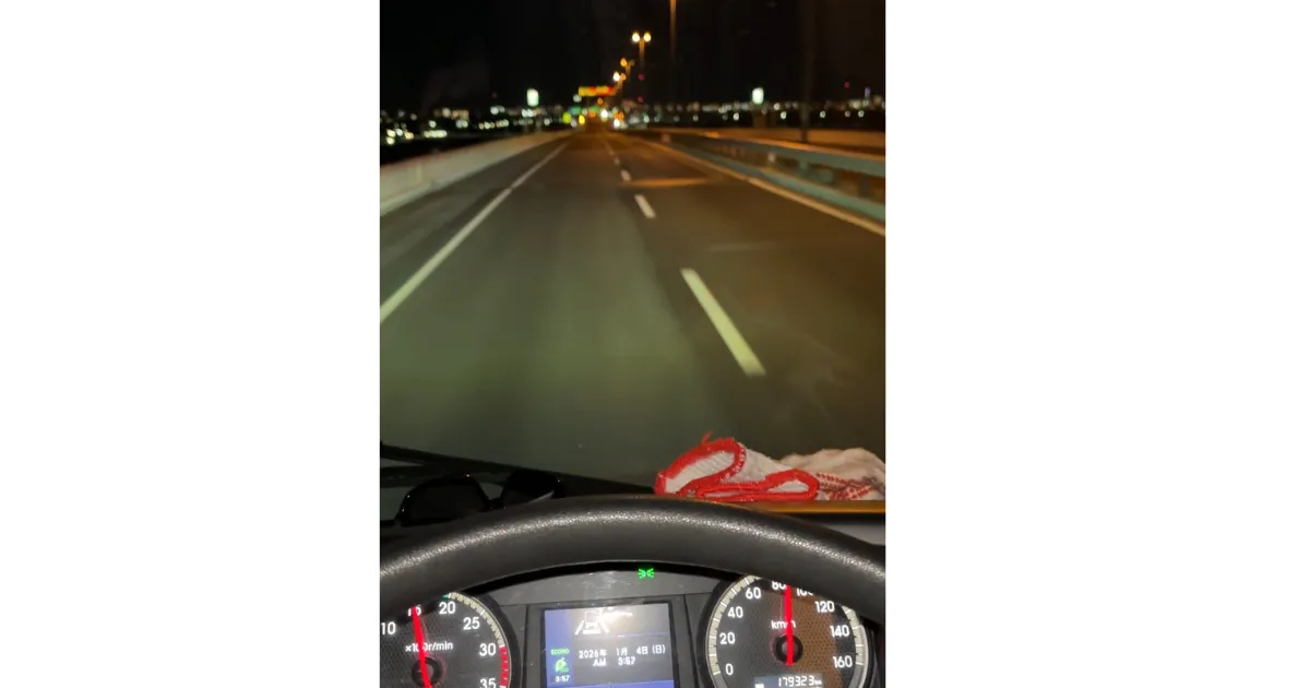 深夜の高速道路を走行する大型トラックの運転席からの視点。ダッシュボードのディスプレイには2026年1月4日午前3時57分と表示され、速度計は約80km/hを指している。